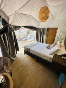 een slaapkamer met een groot bed en een plafond bij Glamping Tortuga Verde in Ocotal