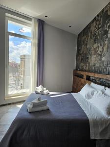 una camera da letto con un grande letto con asciugamani di Binario1 Rooms a Barletta