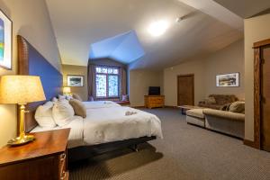 ein großes Schlafzimmer mit einem Bett und einem Sofa in der Unterkunft Copper Horse Lodge in Golden