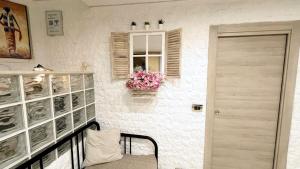 a room with a bench and a window with flowers at Appartamento Suarez Vomero in Naples