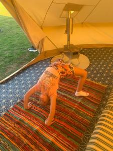 a baby laying on a rug in a tent at Bell Tent in Horspath