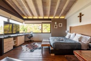 a bedroom with a bed and a desk and window at Hermosa Casa con Terraza y Vista al Lago en Avándaro in Valle de Bravo