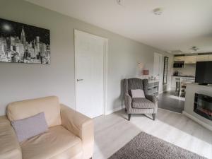 a living room with a couch and a chair at Sunny Cottage in Brecon