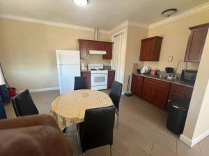 a kitchen with a table with chairs and a white refrigerator at Luxury apartment in Oakland in Oakland +3 photos
