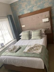 a bedroom with a bed with two towels on it at The Fig Tree Hotel in Shanklin