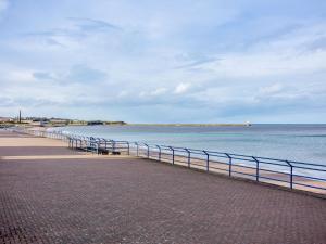 a beach with a fence next to the water at 2 Bed in Berwick-upon-Tweed 82189 in Spittal