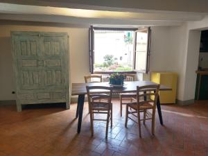 uma sala de jantar com uma mesa e cadeiras e uma janela em Palazzo Reali Apartment - Camera nella storia di Pistoia em Pistoia