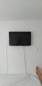 a flat screen tv hanging on a wall above a bed at Badacsonyi családi privát házak in Badacsonytomaj