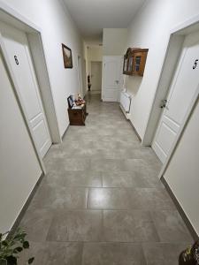 a hallway with white doors and a tile floor at Sleep & Go in Gyhum