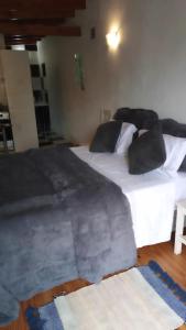 Duas camas num quarto com lençóis e almofadas brancos em LA PAUSA DE ARECO em Martín Fierro