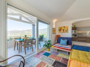 Una habitación con balcón con una mesa y un sofá. en Villa Arcobaleno sul mare, en Terra Mala