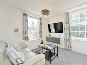 1 Bed in Chester 78221 في تشيستر: غرفة معيشة مع أريكة بيضاء وتلفزيون