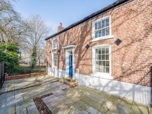 uma casa de tijolos com uma porta azul e um pátio em 1 Bed in Chester 78221 em Chester
