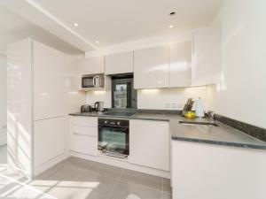 uma cozinha branca com armários e electrodomésticos brancos em 1 Bed in Chester 78221 em Chester