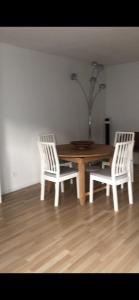 une table en bois entourée de deux chaises blanches dans l'établissement Jeux olympiques 2024, à Montigny-le-Bretonneux