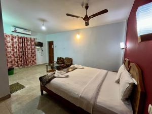 Hotel Ocean Face, BAGA في باغا: غرفة نوم بسرير ومروحة سقف
