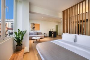 a bedroom with a large white bed and a couch at Pelagus City - Deluxe Apartment I in Thessaloniki