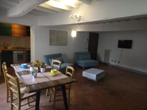 a living room with a wooden table and chairs at Palazzo Reali Apartment - Camera nella storia di Pistoia in Pistoia