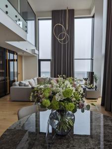 a living room with a vase of flowers on a table at PH106 The best views in Tallinn! in Tallinn