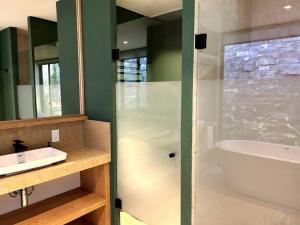 a bathroom with a shower and a tub and a sink at Cabaña Roble Boutique en Avándaro, Valle de Bravo in Valle de Bravo +18 photos