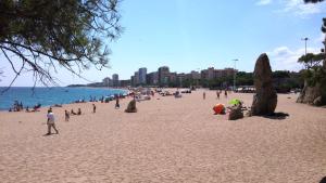 a group of people on a beach near the water at ESLORA in Platja  d'Aro