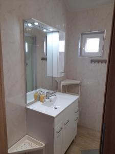 a bathroom with a white sink and a mirror at Malwa Domki Letniskowe in Rusinowo