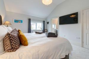 a bedroom with a large white bed with pillows on it at Heathgate House Apartment in Budleigh Salterton