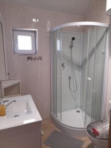 a bathroom with a shower and a sink at Malwa Domki Letniskowe in Rusinowo