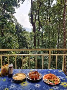 une table bleue avec des assiettes de nourriture sur une terrasse couverte dans l'établissement Jungle valley Munnar, à Munnar