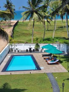 an overhead view of a swimming pool with palm trees at Darshana Beach Hotel in Kosgoda