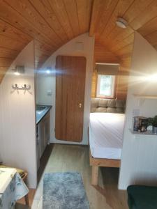 a small bedroom with a bed and a kitchen at Luxe Glamping In A Tiny Home, Adults Only, Dogs Allowed in Lincolnshire