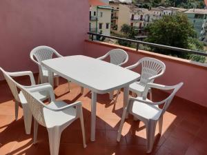 a white table and chairs on a balcony at Grecale in Centola