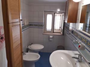 a bathroom with a sink and a toilet and a window at Grecale in Centola +71 photos