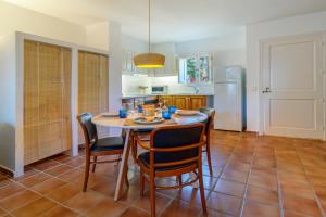 a kitchen with a table and chairs and a refrigerator at Aura de Mar - Dúplex boutique cerca de la playa in Son Xoriguer