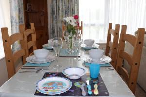 a dining room table with plates and dishes on it at Willow-Oak in Seaview