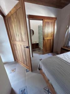a bedroom with a bed and an open door at Casa Celajes Sol in Nosara