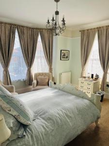 a bedroom with a large bed with a chandelier at Abbotsleigh of Whitby in Whitby