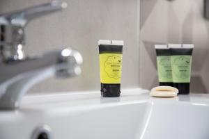 a bathroom sink with two bottles of moisturizers on it at Luz y Diseño en Retiro - Apartamento de 4 Dormitorios in Madrid +38 photos