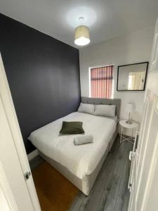 a bedroom with a bed with a black wall at Suite 4 - Stylish Private Room in Old Swan in Liverpool