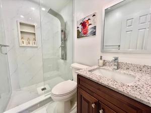 a bathroom with a shower and a toilet and a sink at Newly Renovated Detached Home Near Finch Subway Station in Toronto