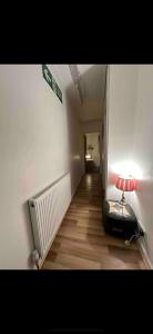 a room with a hallway with a lamp on a floor at Bethnal Green Rooms R4 in London