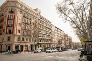a city street with cars parked in front of tall buildings at Luz y Diseño en Retiro - Apartamento de 4 Dormitorios in Madrid