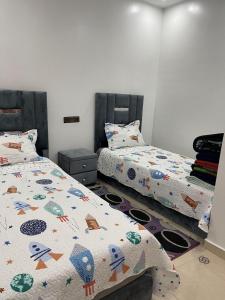 a bedroom with two beds with comforters on them at apartment with terace in Chefchaouene