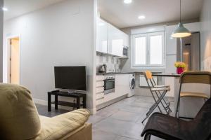 uma sala de estar com um sofá, uma televisão e uma cozinha em Apartamento de 4 dormitorios en Retiro em Madri