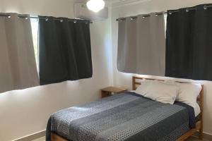 - une chambre avec un lit et une fenêtre avec des rideaux noirs dans l'établissement Scape and relax, à La Sabanita