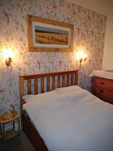 a bedroom with a bed with flowers on the wall at Mapperton Barn House B&B Nr Stourhead & Longleat in Warminster