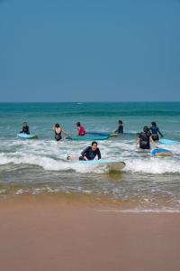 eine Gruppe von Menschen auf Surfbrettern im Ozean in der Unterkunft House Of Surf Hostel for Women in Varkala