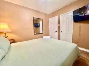 Renovated Rooms 10-min to Finch Subway Near Yonge St في تورونتو: غرفة نوم بها سرير كبير ومرآة