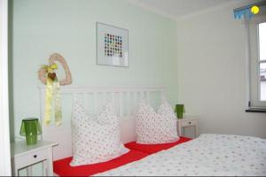 una camera da letto con un letto con cuscini rosa e bianchi di Ferienhaus Rademacher Ferienwohnung 2 a Binz