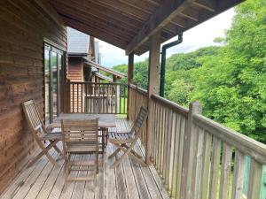 a deck with two chairs and a table on a cabin at Water Mill Vacations Goldfinch - Pet Friendly in Newport